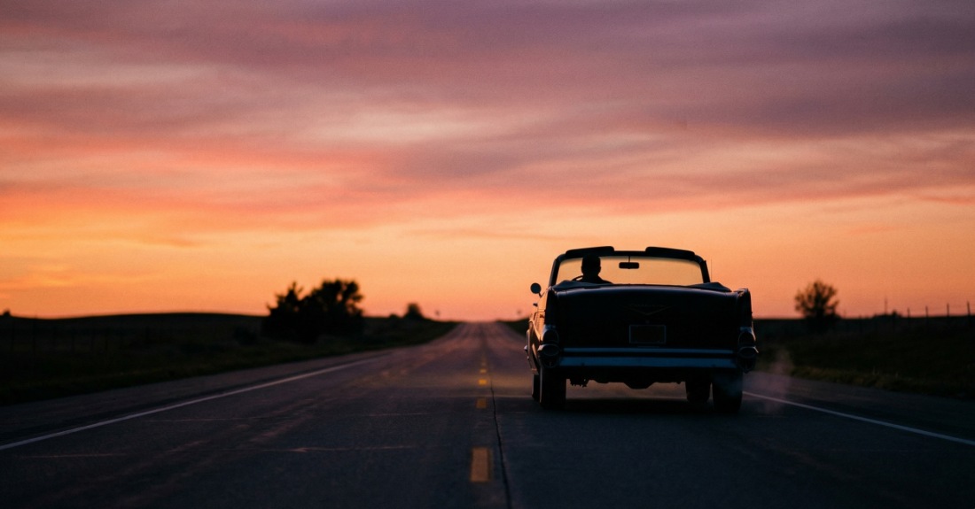 夕暮れのハイウェイを走る車のシルエットや、開けた道を思わせる風景画